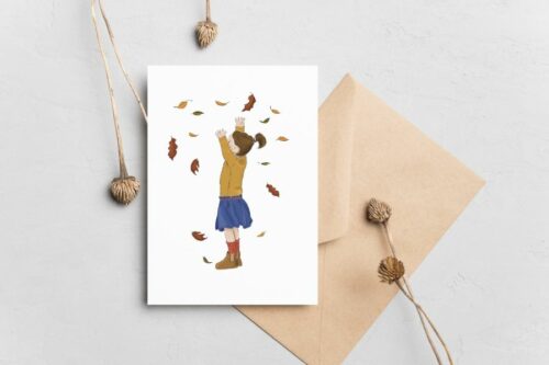 petite fille qui joue avec des feuilles d'automne